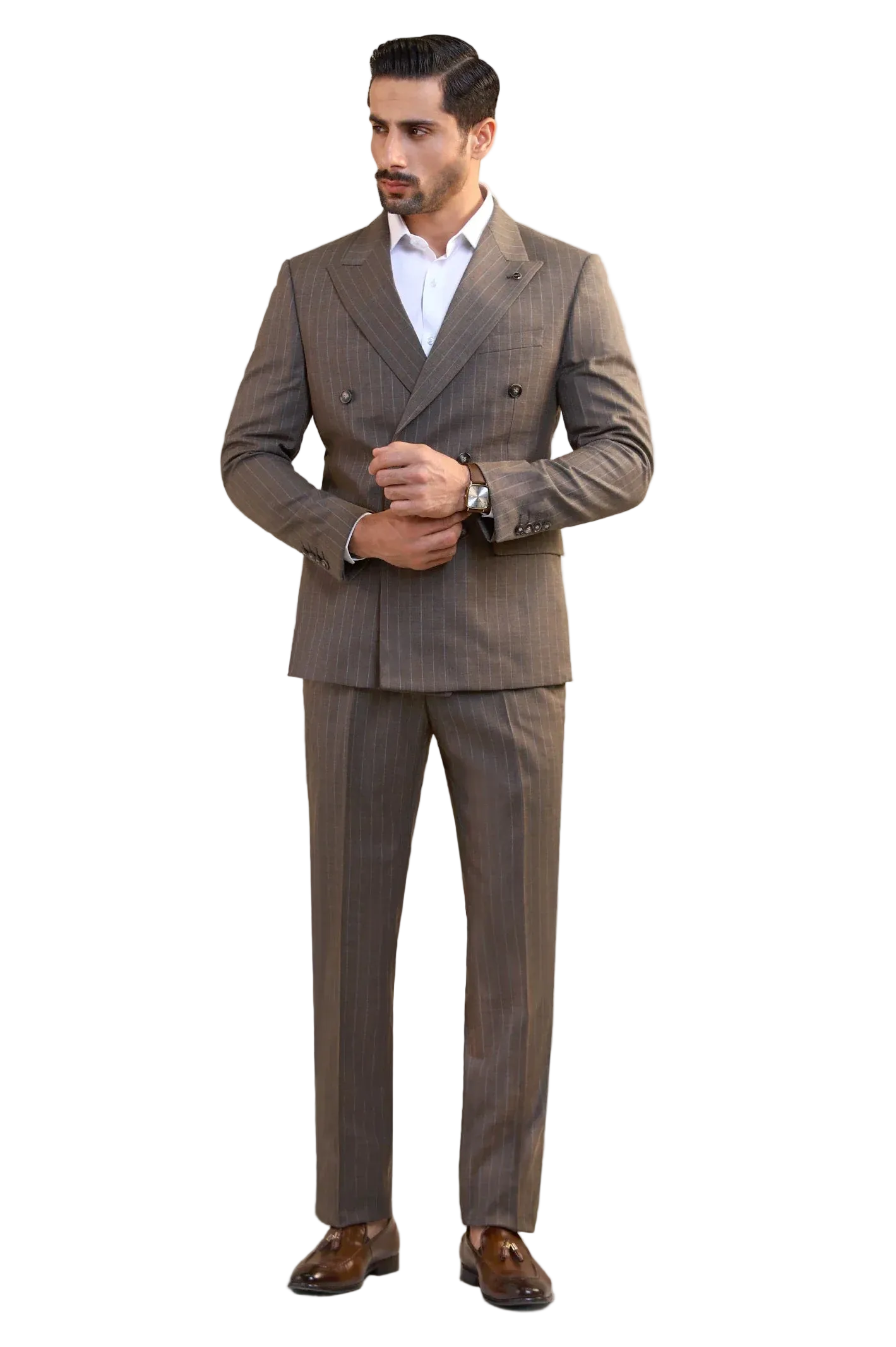 A man wearing a brown double-breasted pinstripe suit with a white dress shirt and brown dress shoes, standing against a light gray studio background.